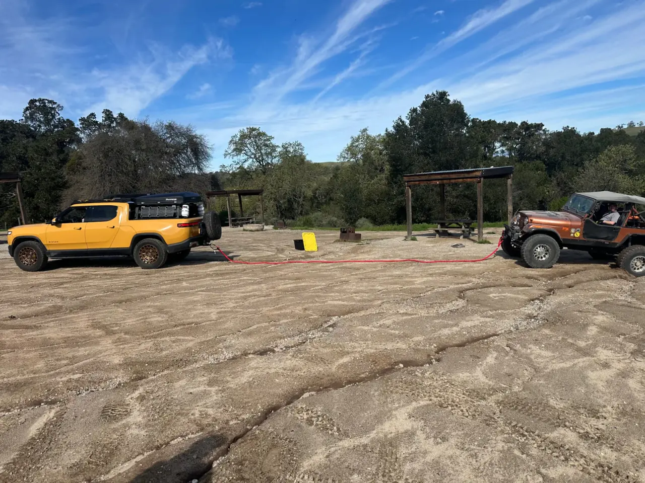 A Rivian and Jeep connected by a kinetic recovery rope during a controlled SNVORA training exercise